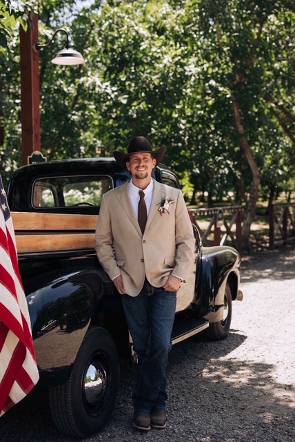 Zach Griffin, founder of Brandwood Ag Services, standing beside a vintage truck on a ranch property